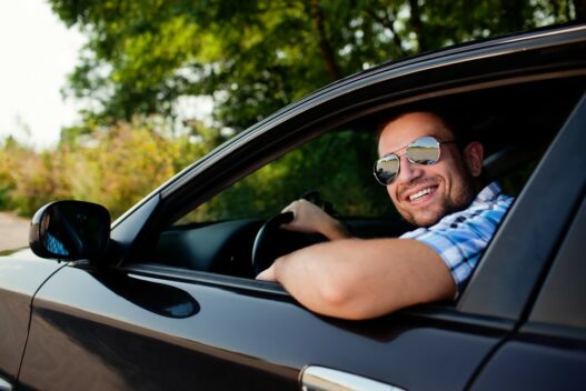 Mand med solbriller i sin bil